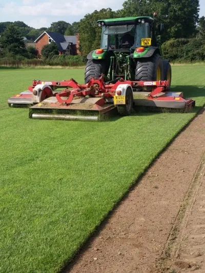 laying fresh turf and trimming with a tractor attachment